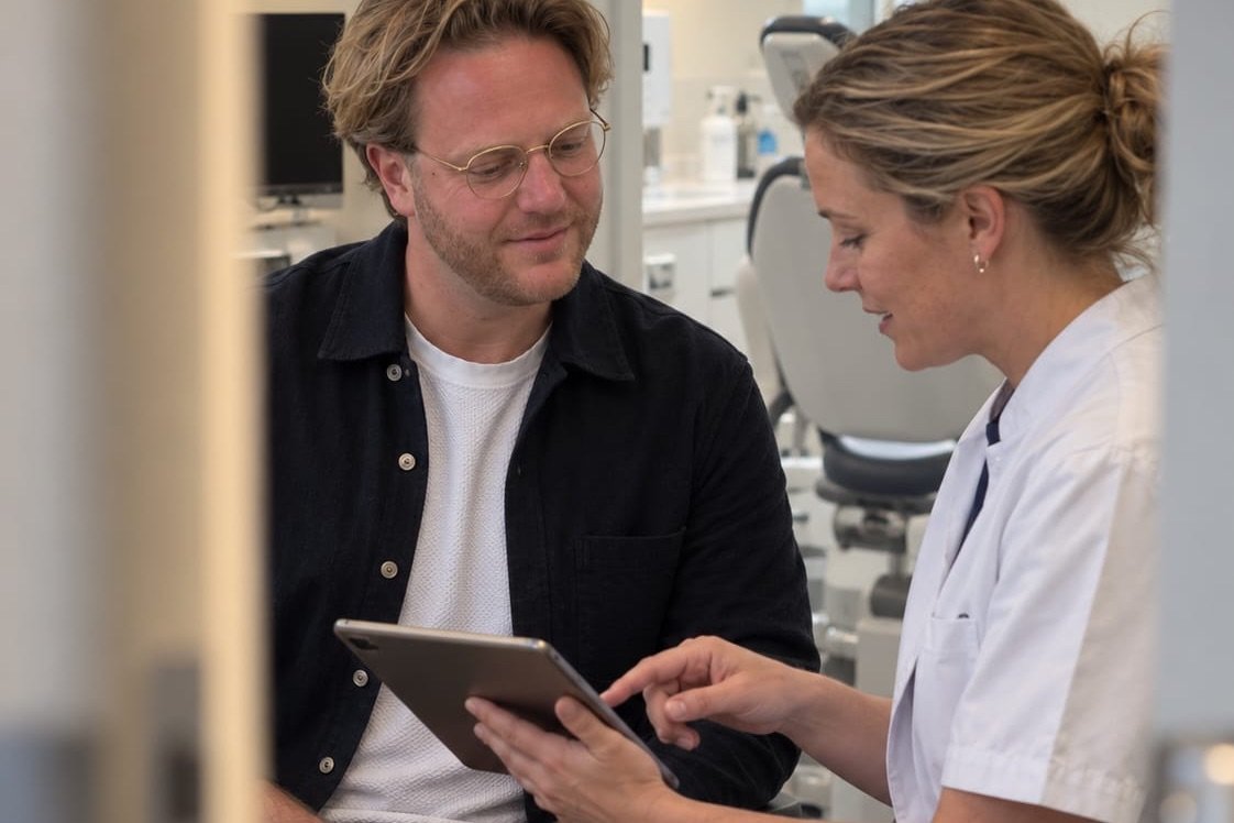 Recruiter Olivier Verwerda van Denta Staffing bekijkt samen met een tandarts een tablet in de praktijk
