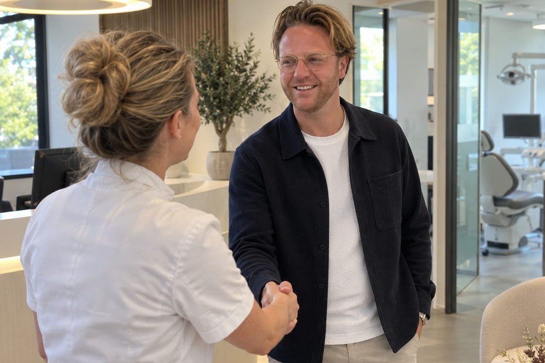 Recruiter Olivier Verwerda schudt een praktijkmedewerker de hand bij de receptie van een tandartspraktijk